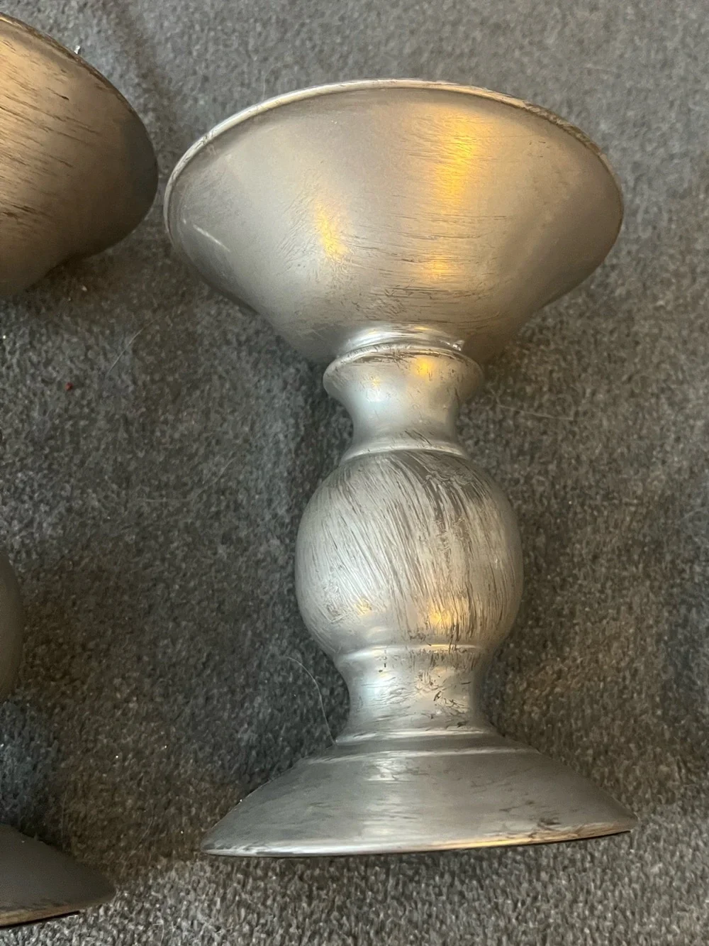 set of three silver-tone metal candlestick holders features a graduated design